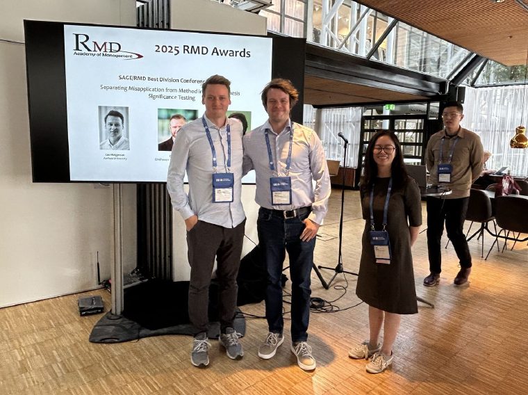 Jesper N. Wulff and Lau Abild Holgersen in front of the 2025 RMD Awards screen at the Academy of Management meeting